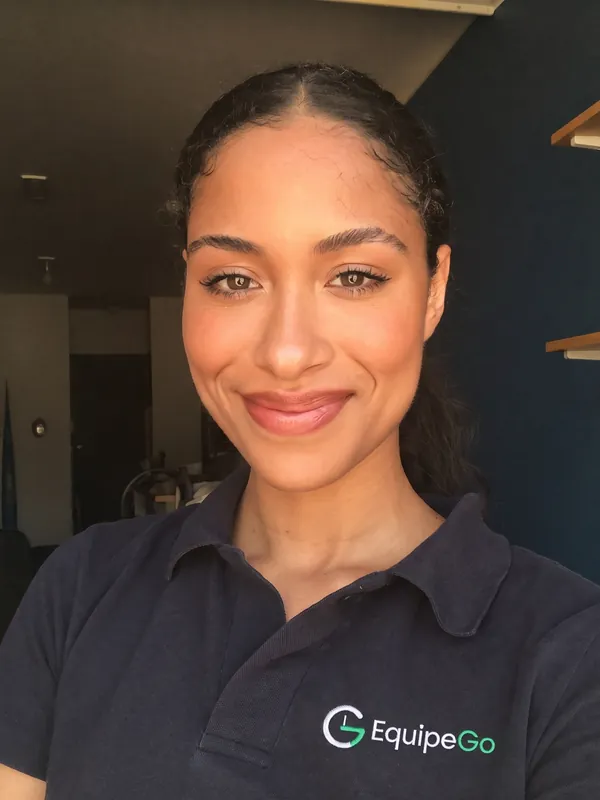 Camila, colaboradora fictícia de uniforme da EquipeGo, com o rosto enquadrado para a selfie